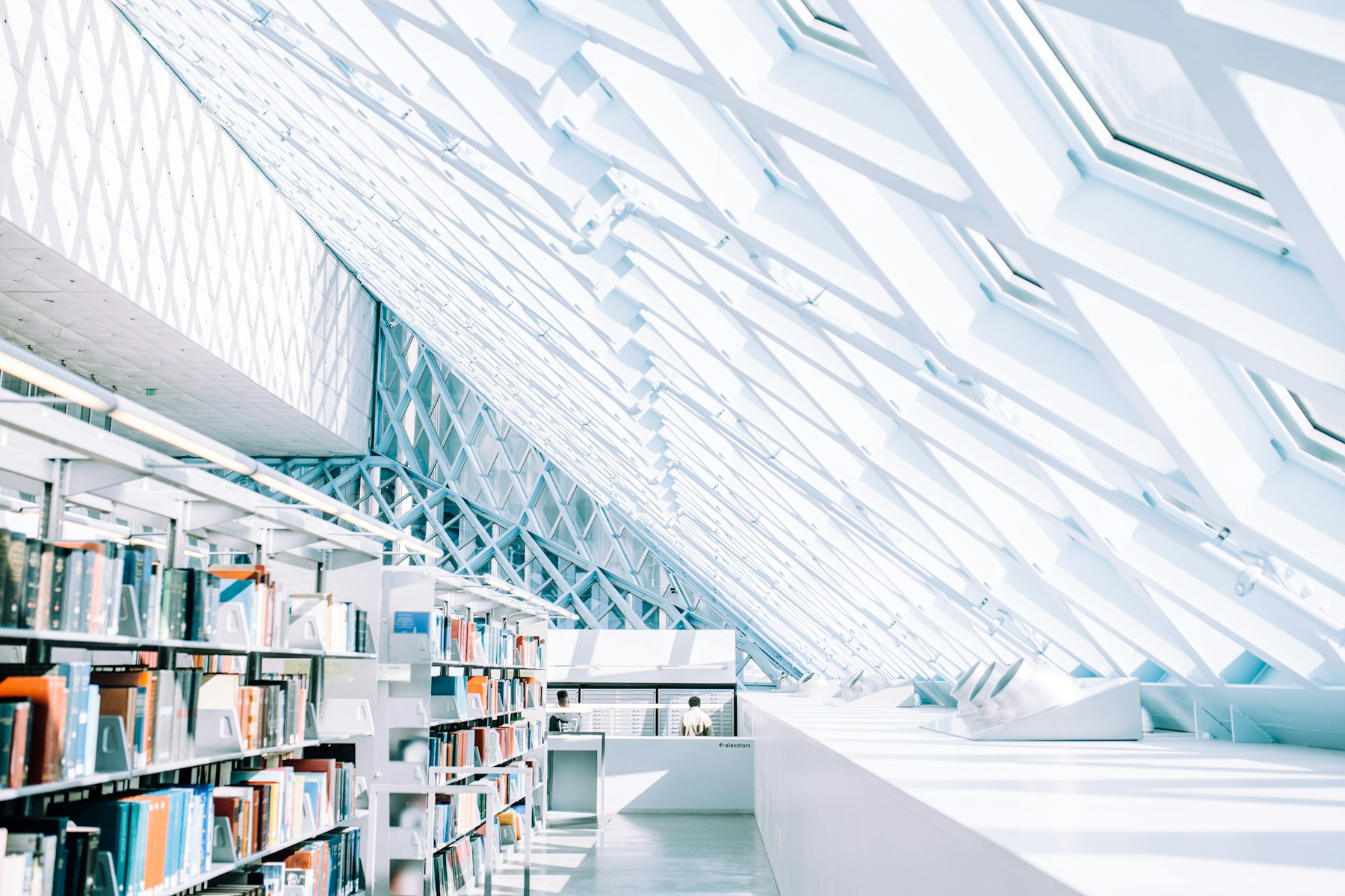 Bookshelves beneath the geometric glass roof of Seattle Public Library